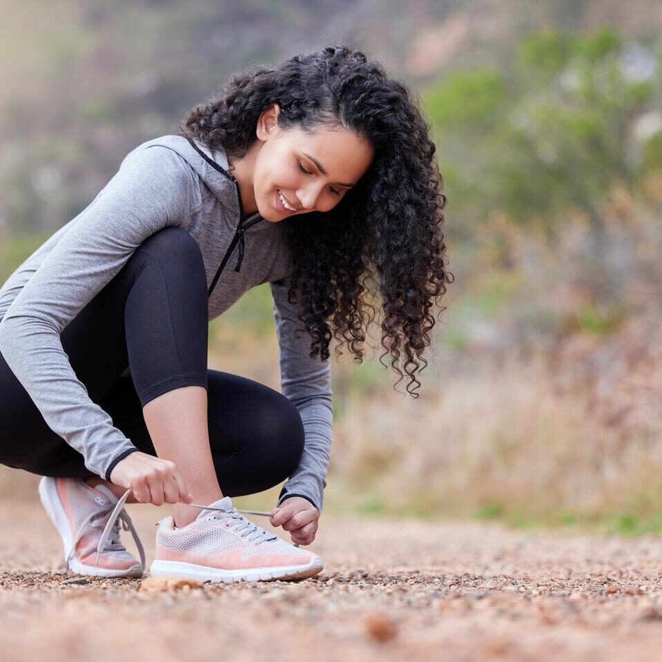 He said dont trip, I though he meant my laces are loose. Shot of a woman tying her shoelaces while out on a trail for a run. He said dont trip, I though he meant my laces are loose. Shot of a woman tying her shoelaces while out on a trail for a run.